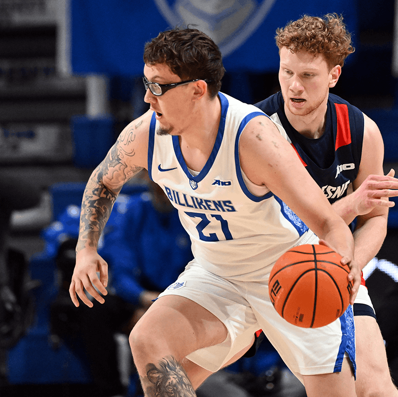 A basketball player wearing number 21 dribbles a ball while running up a court.