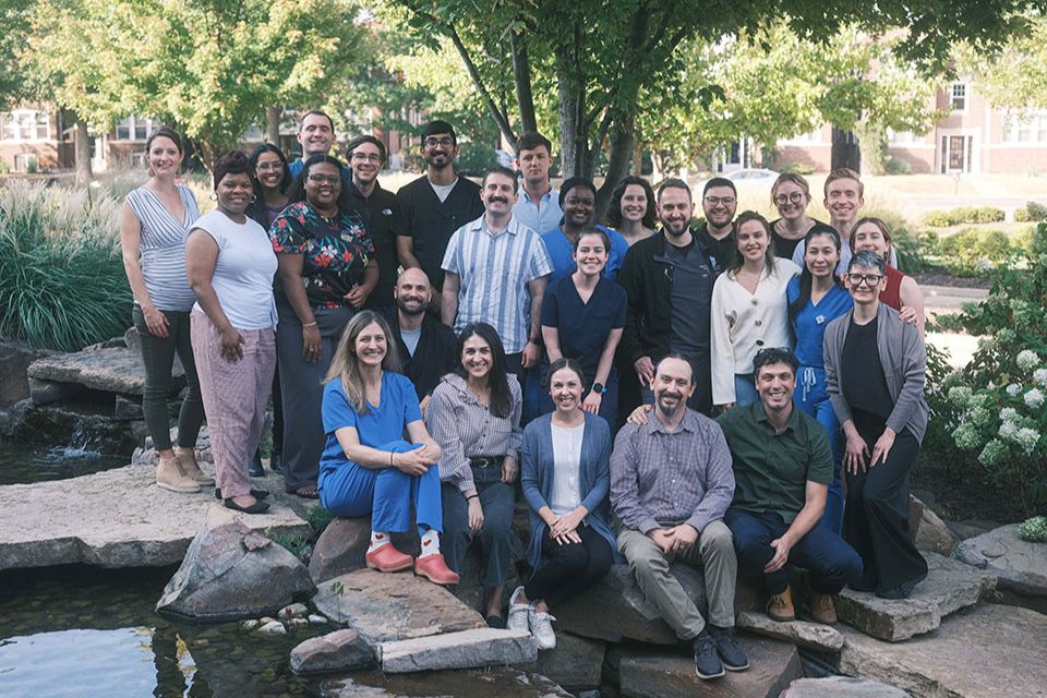 Family medicine residents, faculty and staff pose outdoors on SLU's campus